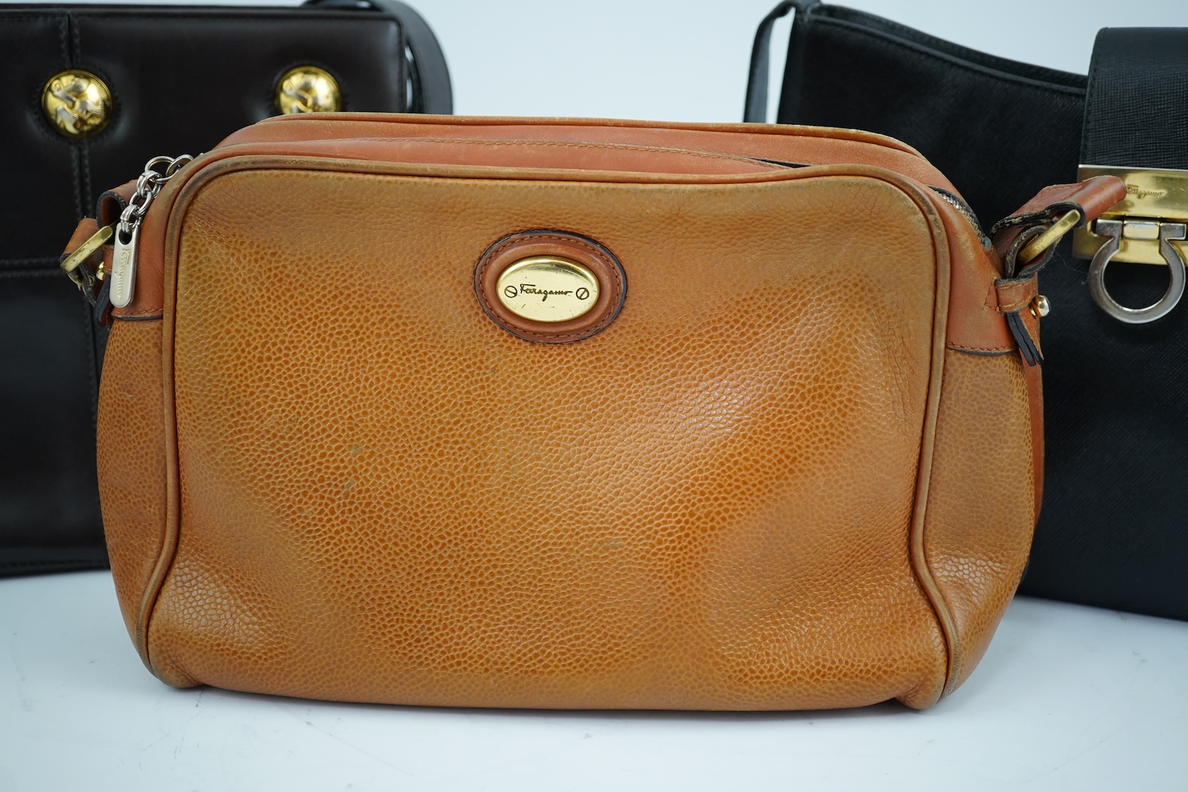 A Salvatore Ferragamo brown leather shoulder bag, and two other handbags